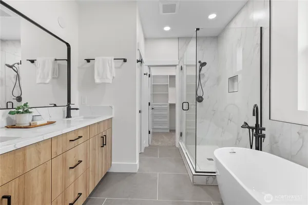a bathroom with a tub a sink shower and mirror