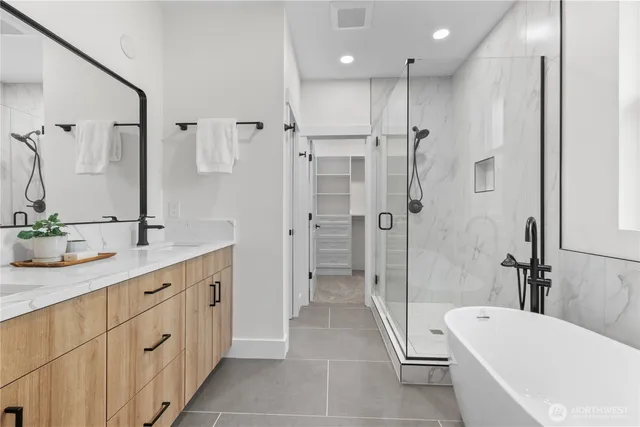 a bathroom with a tub a sink shower and mirror