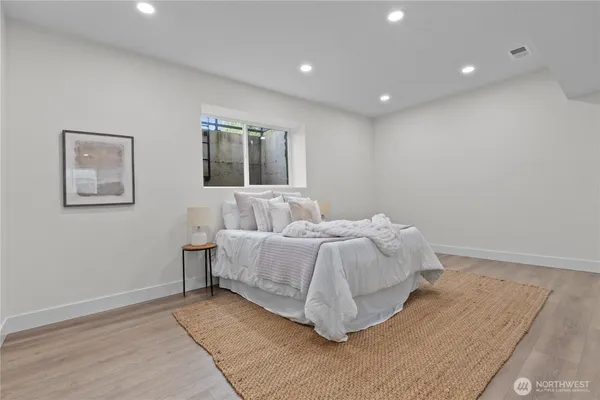 a spacious bedroom with a bed and painting on the wall