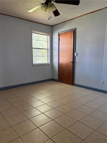 an empty room with a ceiling fan and window