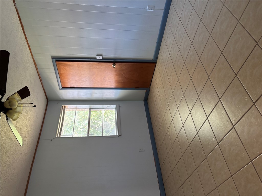 411 Hickory Street Calvert, TX 77837 - Photo 7 of 9 an empty room with a ceiling fan and window