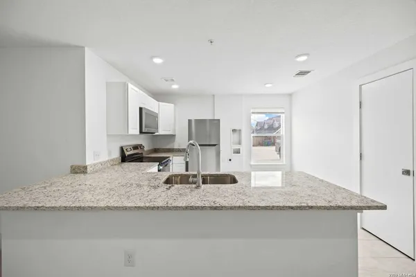 a kitchen with kitchen island granite countertop a sink and center island