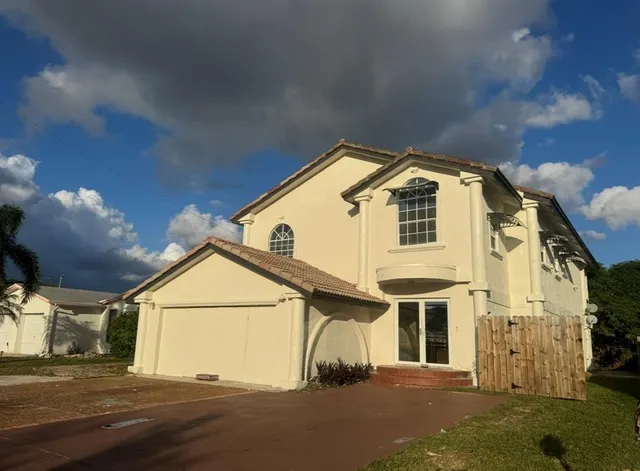 a view of a white house with a street