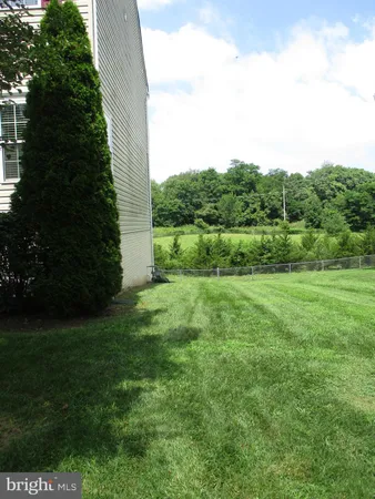 a view of green field with trees in the background