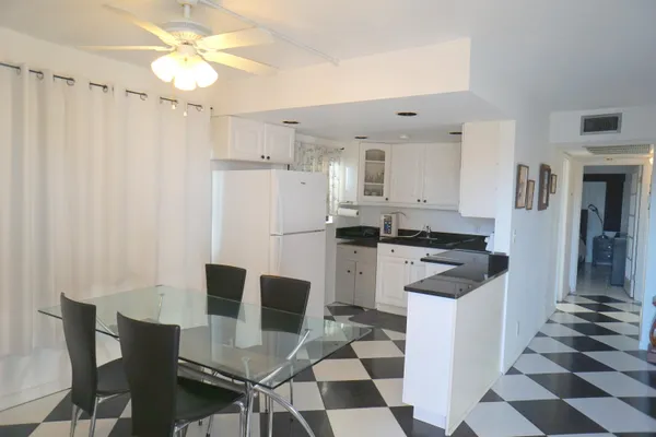 a kitchen with stainless steel appliances a stove a refrigerator and white cabinets
