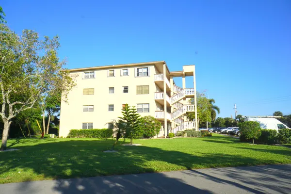a view of a big building with a big yard and plants