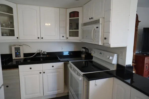 a kitchen with granite countertop a stove and a sink
