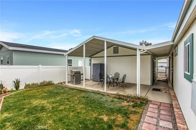 a backyard of a house with table and chairs