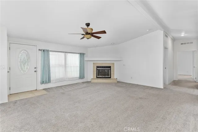 a view of an empty room with a fireplace and a window
