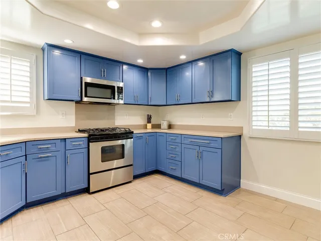 a kitchen with stainless steel appliances granite countertop a stove microwave and sink