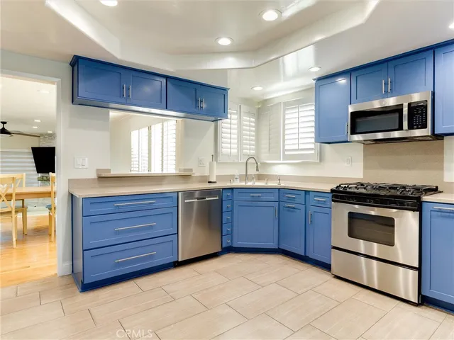 a kitchen with stainless steel appliances granite countertop wooden cabinets a stove a sink and a window