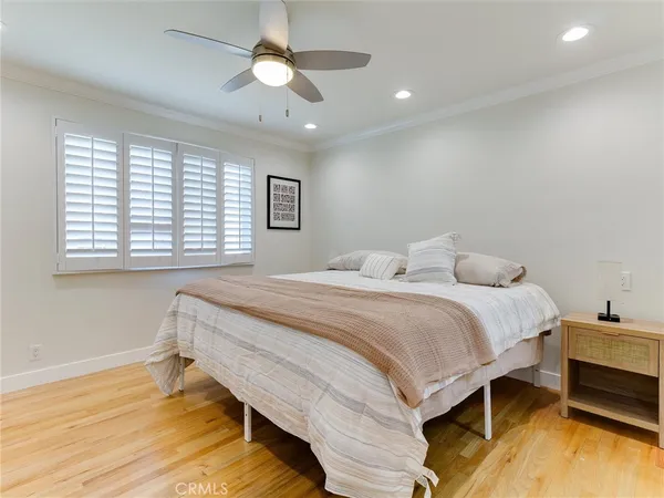 a bedroom with a bed chandelier and a window