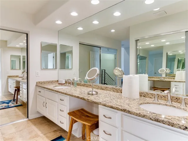 a bathroom with a granite countertop double vanity and a mirror