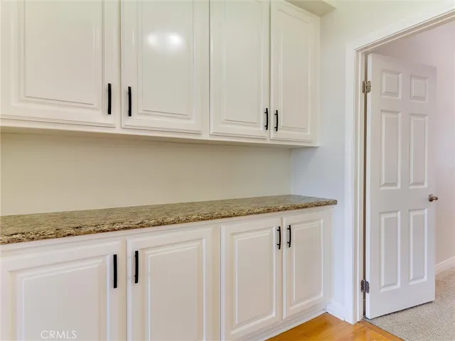 a kitchen with granite countertop white cabinets and a sink