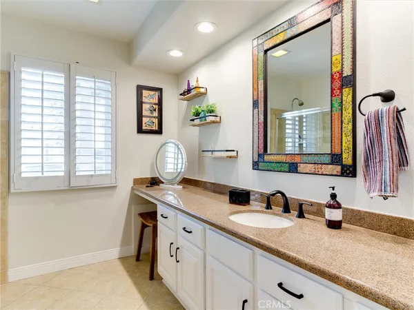 a bathroom with a granite countertop double vanity sink and a mirror