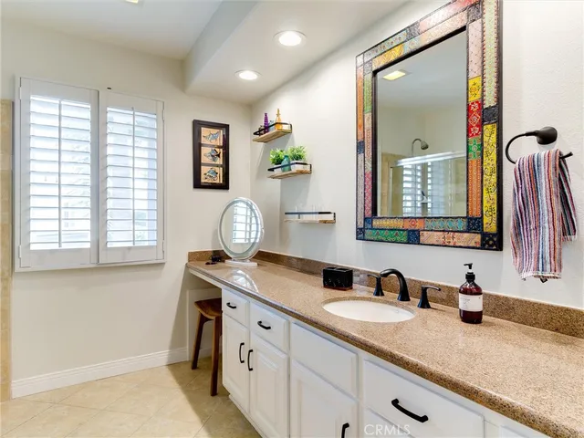 a bathroom with a granite countertop double vanity sink and a mirror