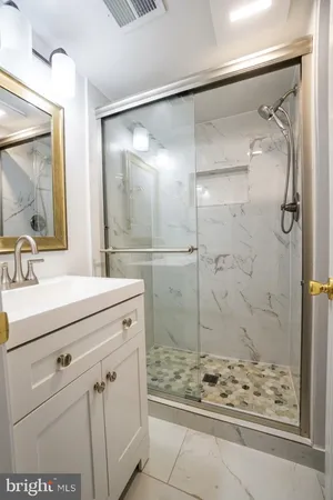 a bathroom with a shower sink and mirror