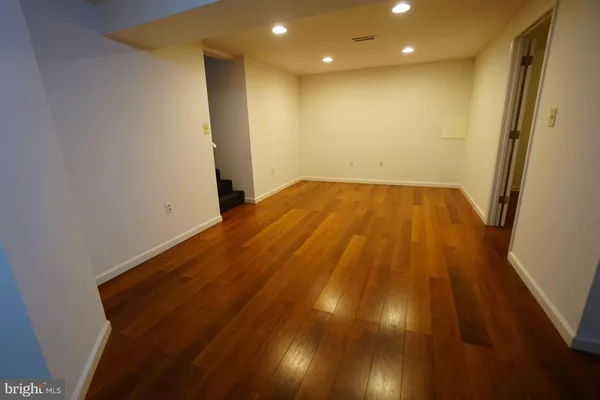 a view of empty room with wooden floor