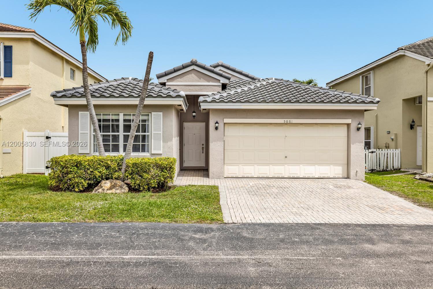 5861 South Sable Circle Margate, FL 33063 - Photo 1 of 56 a front view of a house with a yard and garage