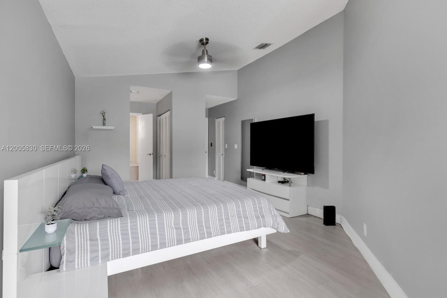 5861 South Sable Circle Margate, FL 33063 - Photo 17 of 56 a bedroom with a bed and a flat tv screen on wall