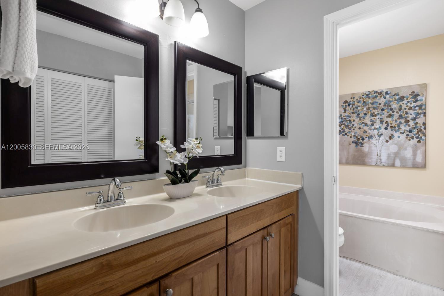 5861 South Sable Circle Margate, FL 33063 - Photo 18 of 56 a bathroom with a sink double vanity granite tub shower and a mirror
