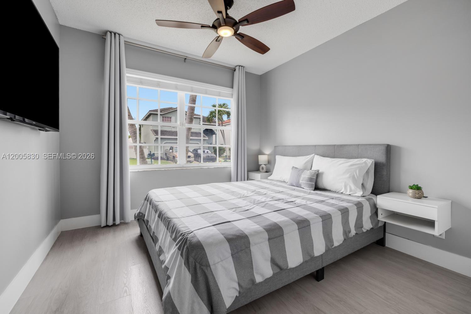 5861 South Sable Circle Margate, FL 33063 - Photo 21 of 56 a bedroom with a large bed and a flat tv screen on dresser