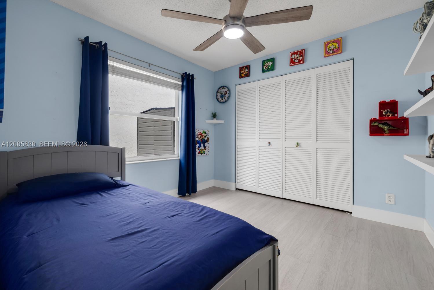 5861 South Sable Circle Margate, FL 33063 - Photo 25 of 56 a bedroom with a bed and a chandelier fan