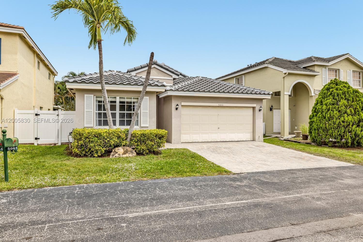 5861 South Sable Circle Margate, FL 33063 - Photo 35 of 56 a view of a white house with a small yard and a large parking space