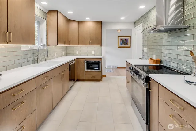 a kitchen with stainless steel appliances kitchen island granite countertop a sink and a stove