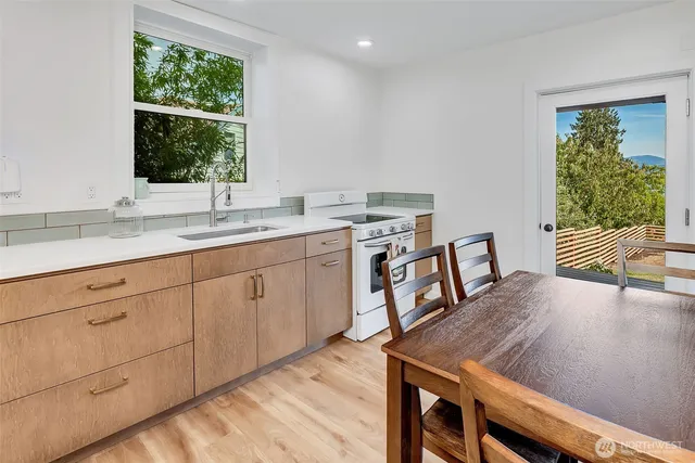 a kitchen with a table chairs cabinets and wooden floor