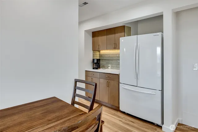 a kitchen with a refrigerator and a stove top oven