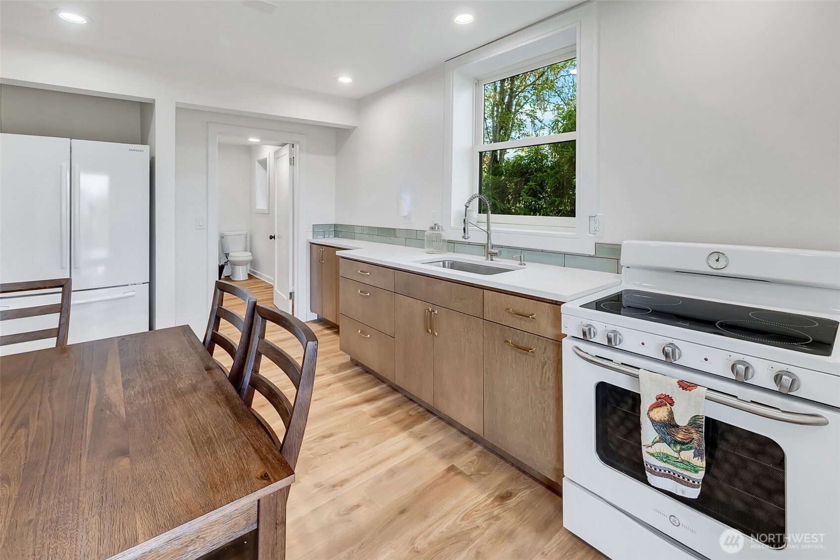 9804 63rd Avenue South Seattle, WA 98118 - Photo 34 of 40 a kitchen with a stove a sink and a refrigerator