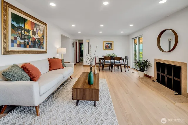 a living room with furniture a large window and a fireplace