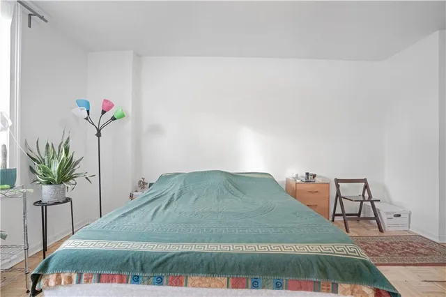 a bedroom with a bed and a potted plant