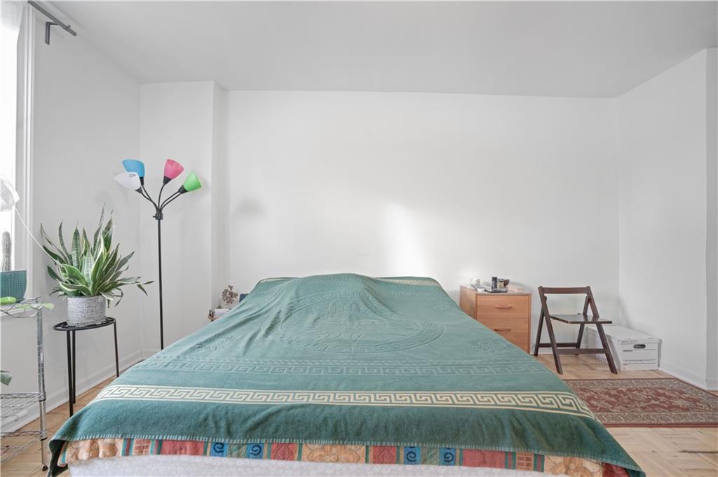 1075 Sheepshead Bay Road, Unit 2S Brooklyn, NY 11229 - Photo 17 of 30 a bedroom with a bed and a potted plant
