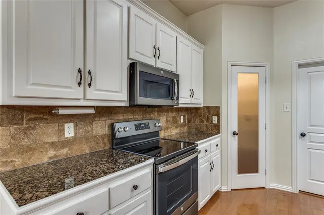 a kitchen with stainless steel appliances granite countertop a stove a microwave and cabinets