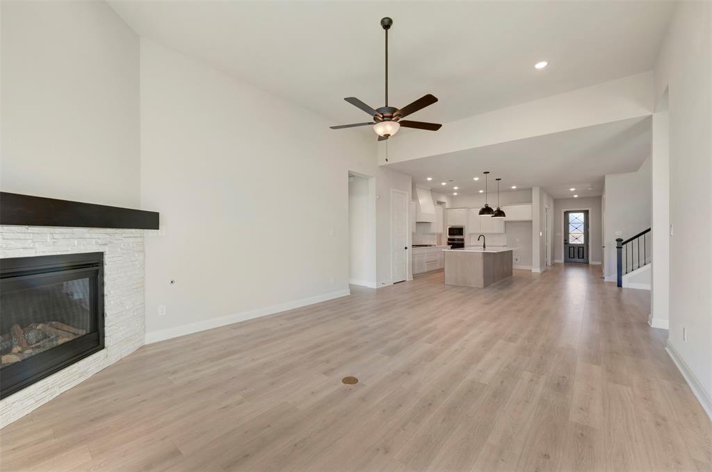 3575 Redbud Flower Trail Venus, TX 76084 - Photo 27 of 36 Unfurnished living room with light wood-style flooring, recessed lighting, a stone fireplace, and ceiling fan