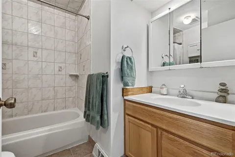 a bathroom with a granite countertop sink and a mirror a bathtub
