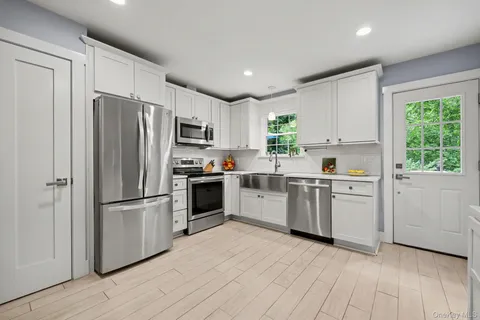 a kitchen with granite countertop a refrigerator a stove top oven a sink and dishwasher
