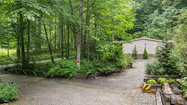 a backyard of a house with lots of green space and fountain in the back