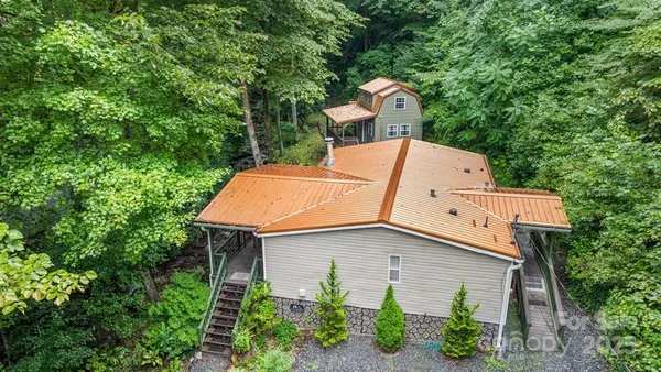 an aerial view of a house with a yard and large tree