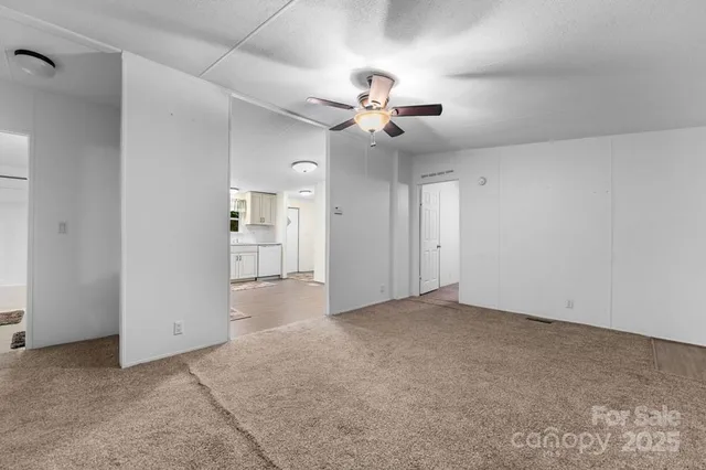 a view of an empty room with a ceiling fan
