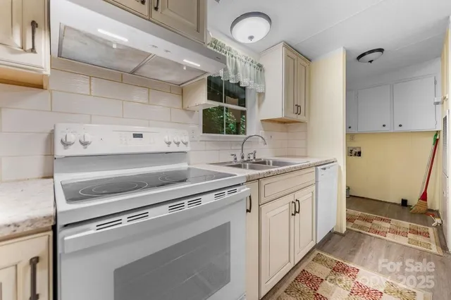 a kitchen with granite countertop a sink stainless steel appliances and cabinets