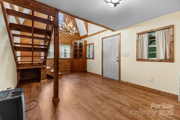 a view of empty room with a window and wooden floor