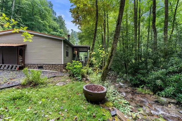 a view of a backyard with potted plants and large trees