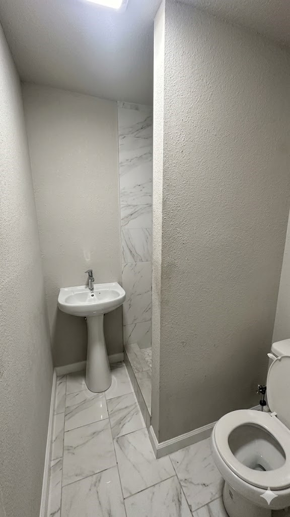 425 Hawthorne Street, Unit 12 Houston, TX 77006 - Photo 3 of 6 a bathroom with a sink toilet and a mirror