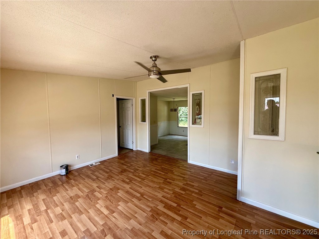 135 Snowhill Church Road Fayetteville, NC 28306 - Photo 2 of 13 a view of a livingroom with wooden floor and a ceiling fan