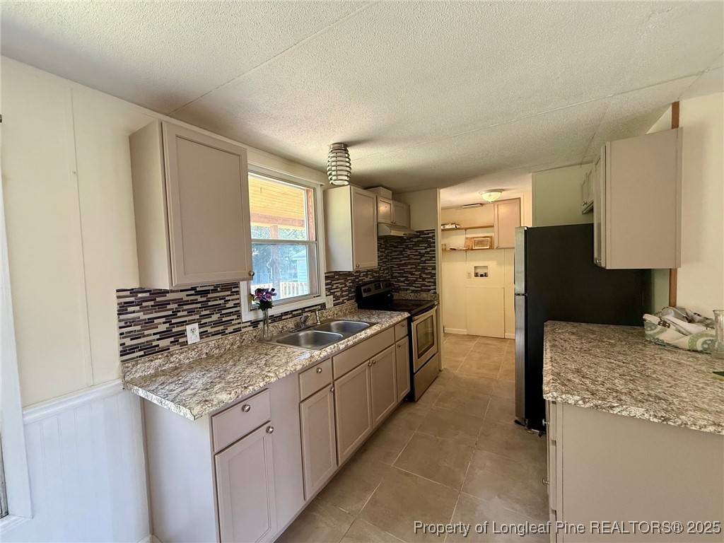 135 Snowhill Church Road Fayetteville, NC 28306 - Photo 3 of 13 a kitchen with a granite countertop sink stove and refrigerator