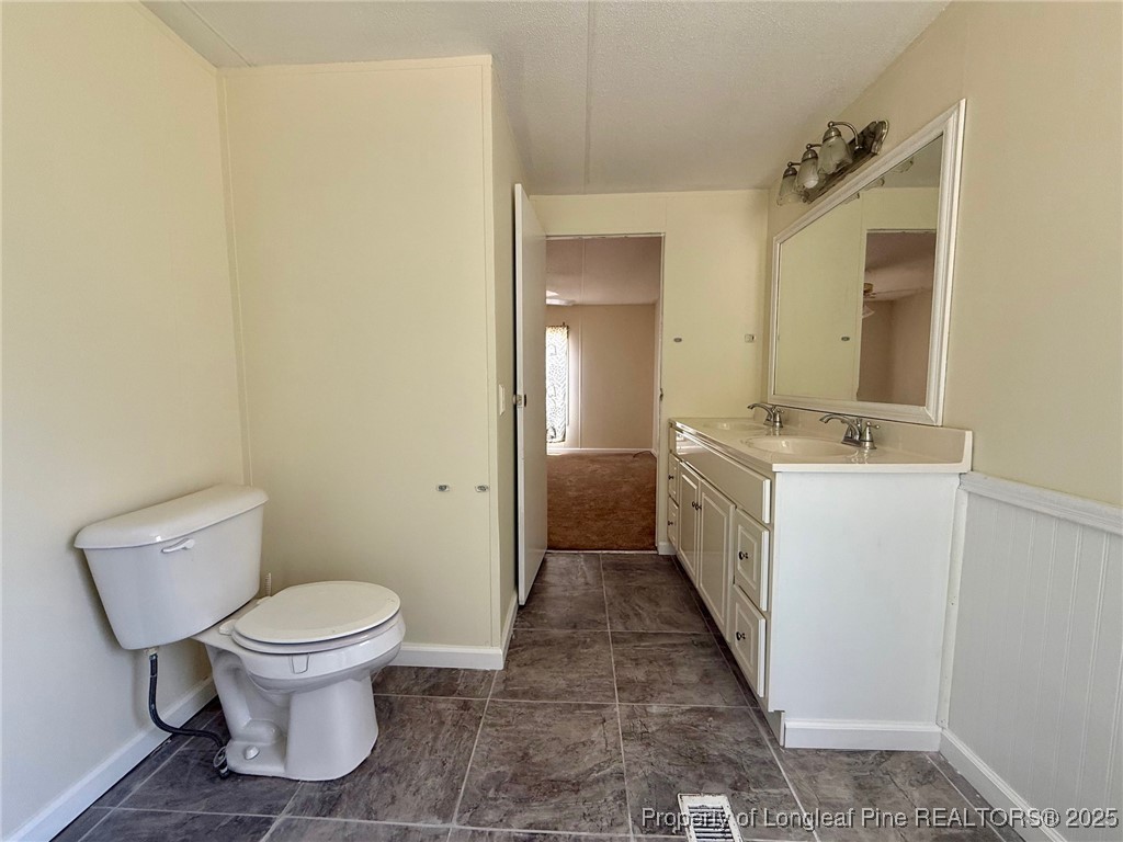 135 Snowhill Church Road Fayetteville, NC 28306 - Photo 7 of 13 a bathroom with a sink a toilet and a mirror