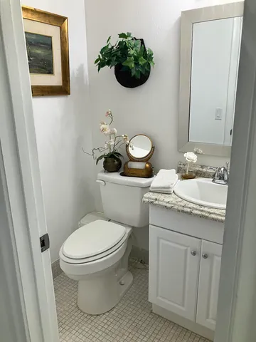 a bathroom with a granite countertop toilet and a sink